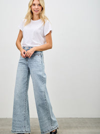 Model wearing High Rise Wide Leg jeans paired with a basic white t-shirt and stylish heels.