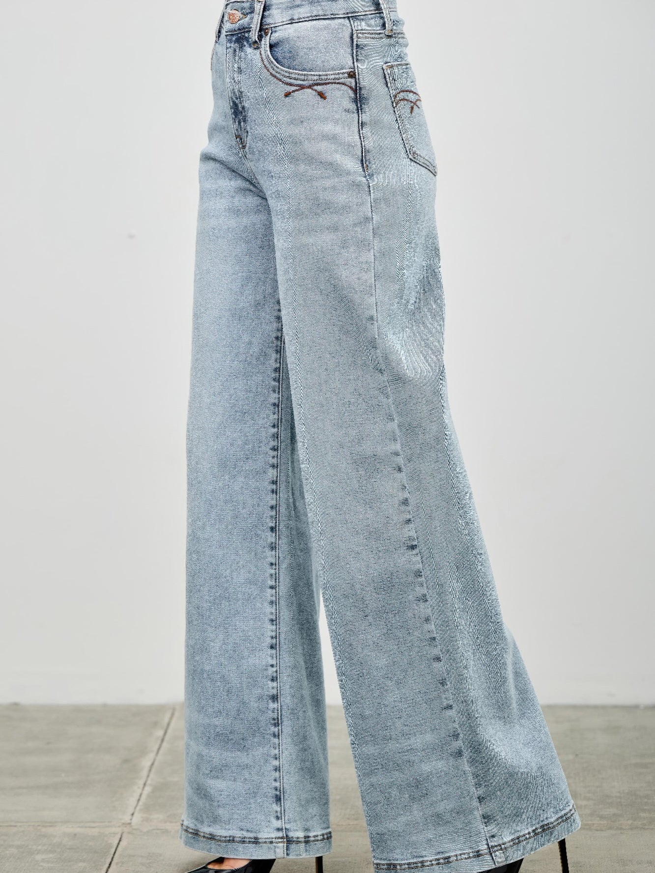 High Rise Wide Leg jeans in light wash, featuring a flattering high rise and wide leg design for comfort and style.