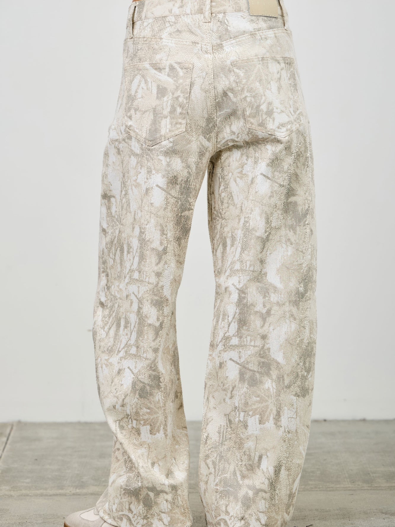 High Rise Low Curve Barrel jeans showcasing a unique printed design and high-rise waist, viewed from the back.