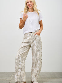 Model wearing High Rise Low Curve Barrel jeans with a printed design and casual white t-shirt, showcasing contemporary style.