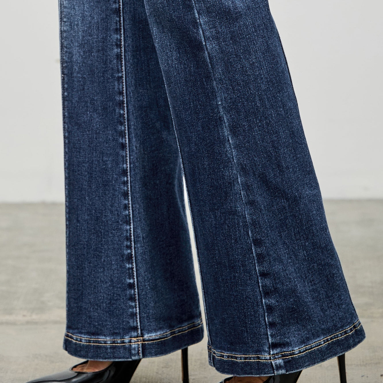 High Rise Boot Cut With Seam Detail showcasing flared hem paired with stylish black heels.