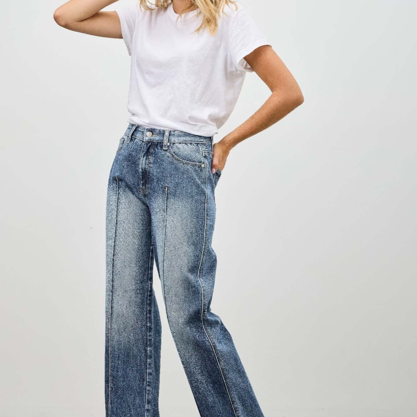 Model wearing Mid Rise Straight With Pintuck jeans and a white t-shirt, showcasing stylish denim fashion.