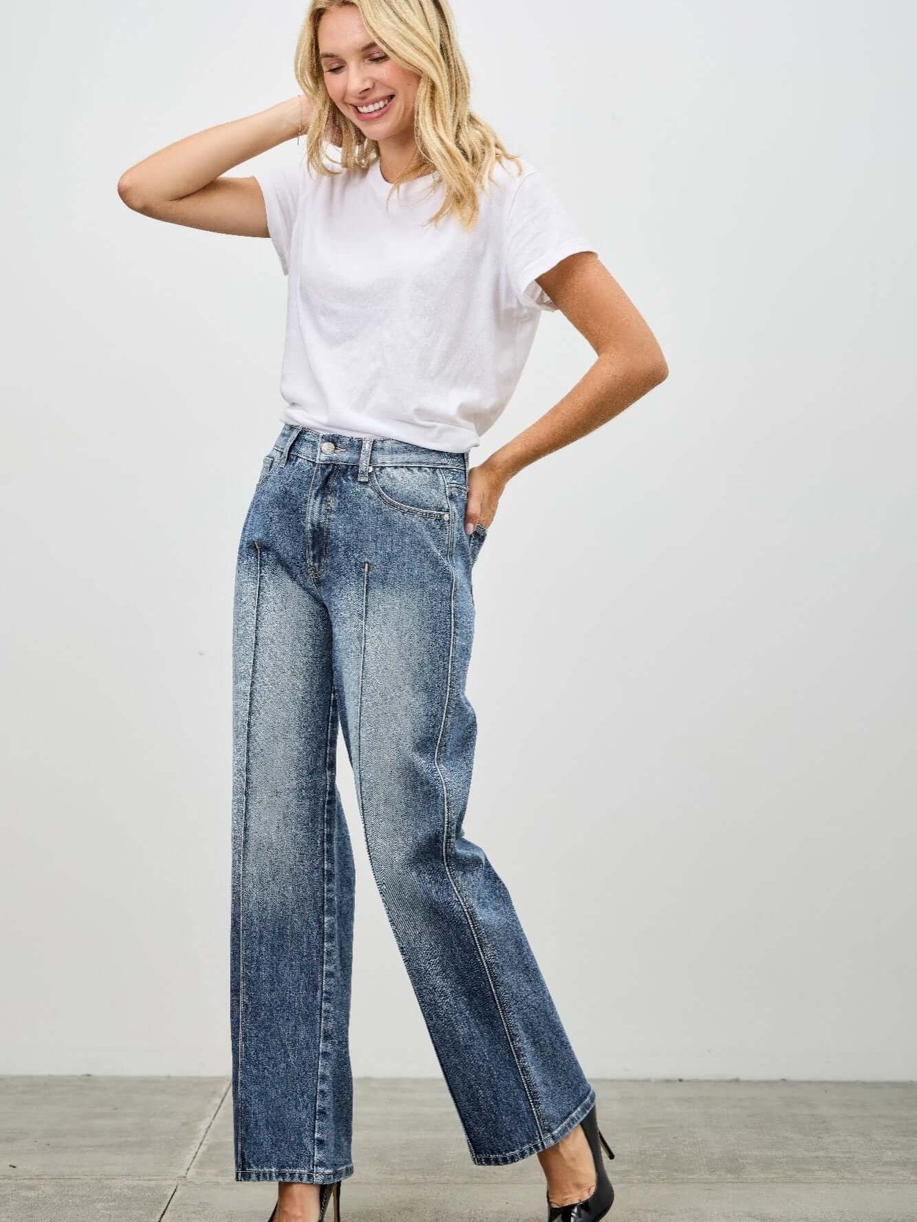 Model wearing Mid Rise Straight With Pintuck jeans and a white t-shirt, showcasing stylish denim fashion.