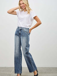 Model wearing Mid Rise Straight With Pintuck jeans and a white t-shirt, showcasing stylish denim fashion.