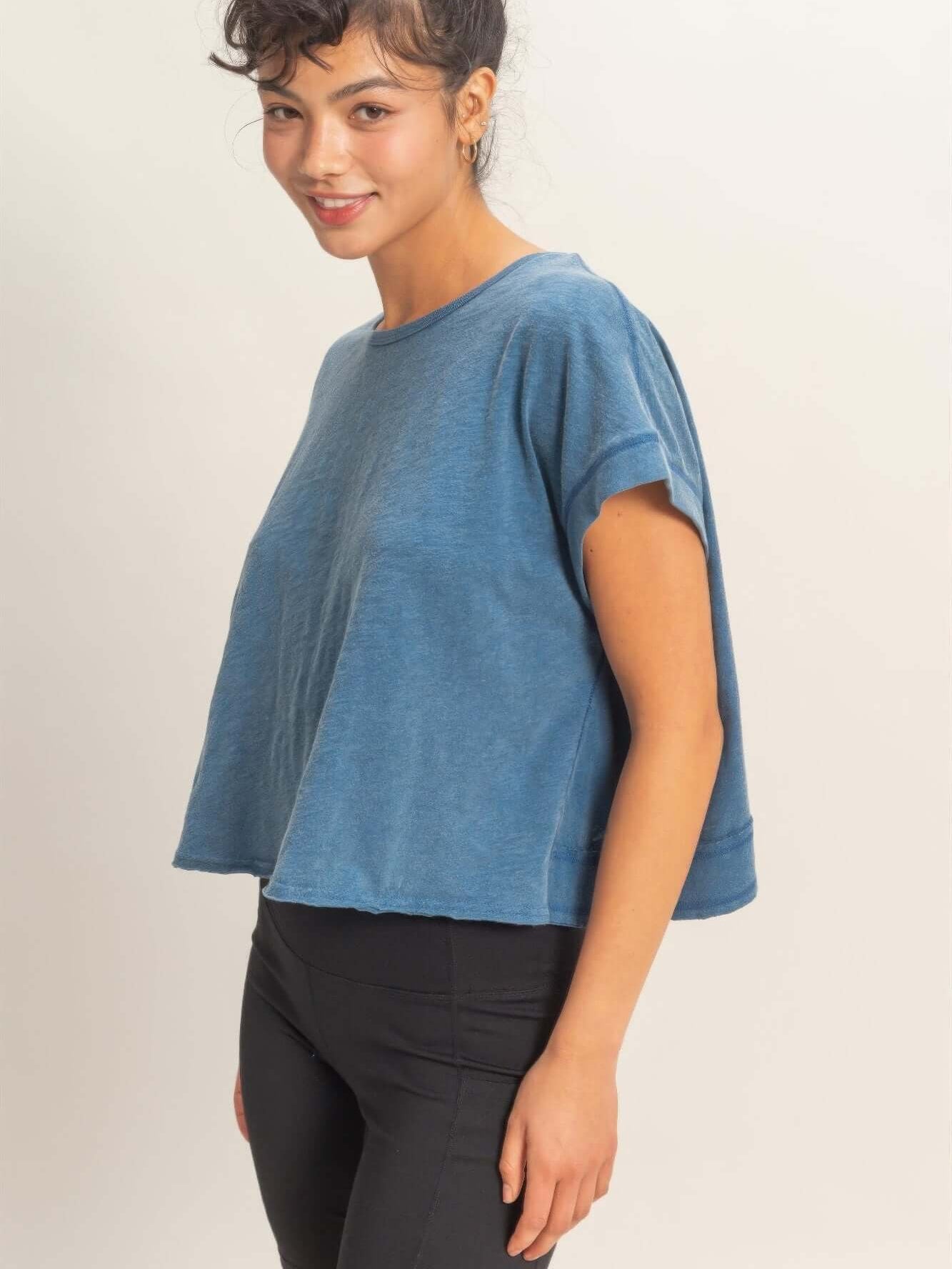 Acid Washed Cross Detail Open Back Top in blue displayed on a model, showcasing the unique open back and relaxed fit.