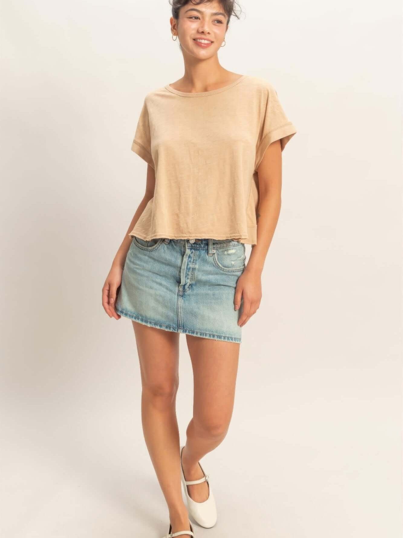 Model wearing an Acid Washed Cross Detail Open Back Top with a denim skirt, showcasing a chic casual look.