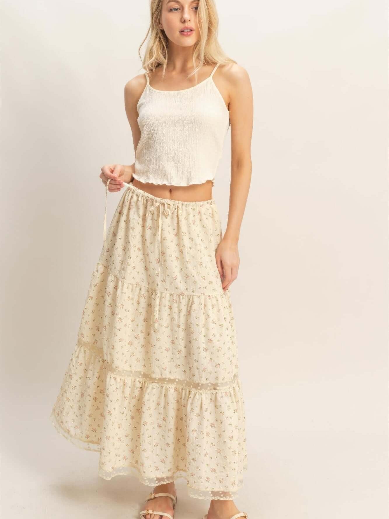 Model wearing a stylish Tiered Lace Trim Skirt with floral design, paired with a casual tank top.