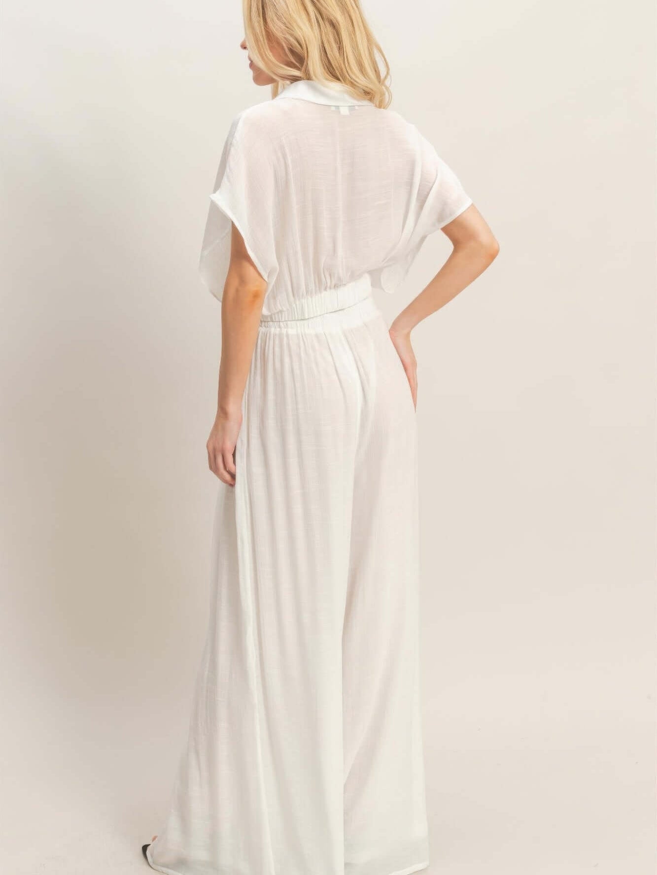 Woman wearing a Collared Wrap Top & Wide-leg Pants Set in white, showcasing the back view and flowing silhouette.