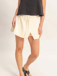 Model wearing a stylish Wrap Front Elastic Waist Skort in soft cream fabric for active, polished performance.