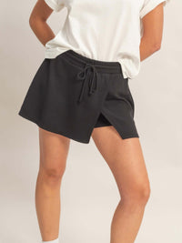 Model wearing a Wrap Front Elastic Waist Skort in black, showcasing its stylish and comfortable design.