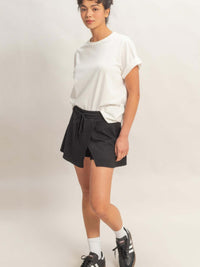 Woman wearing a casual outfit featuring a Wrap Front Elastic Waist Skort and a white t-shirt, styled for comfort.