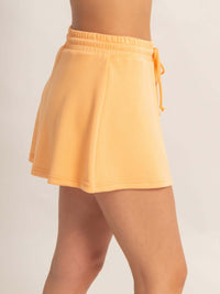 Wrap Front Elastic Waist Skort in a soft peach color with an elastic waistband and flared design.