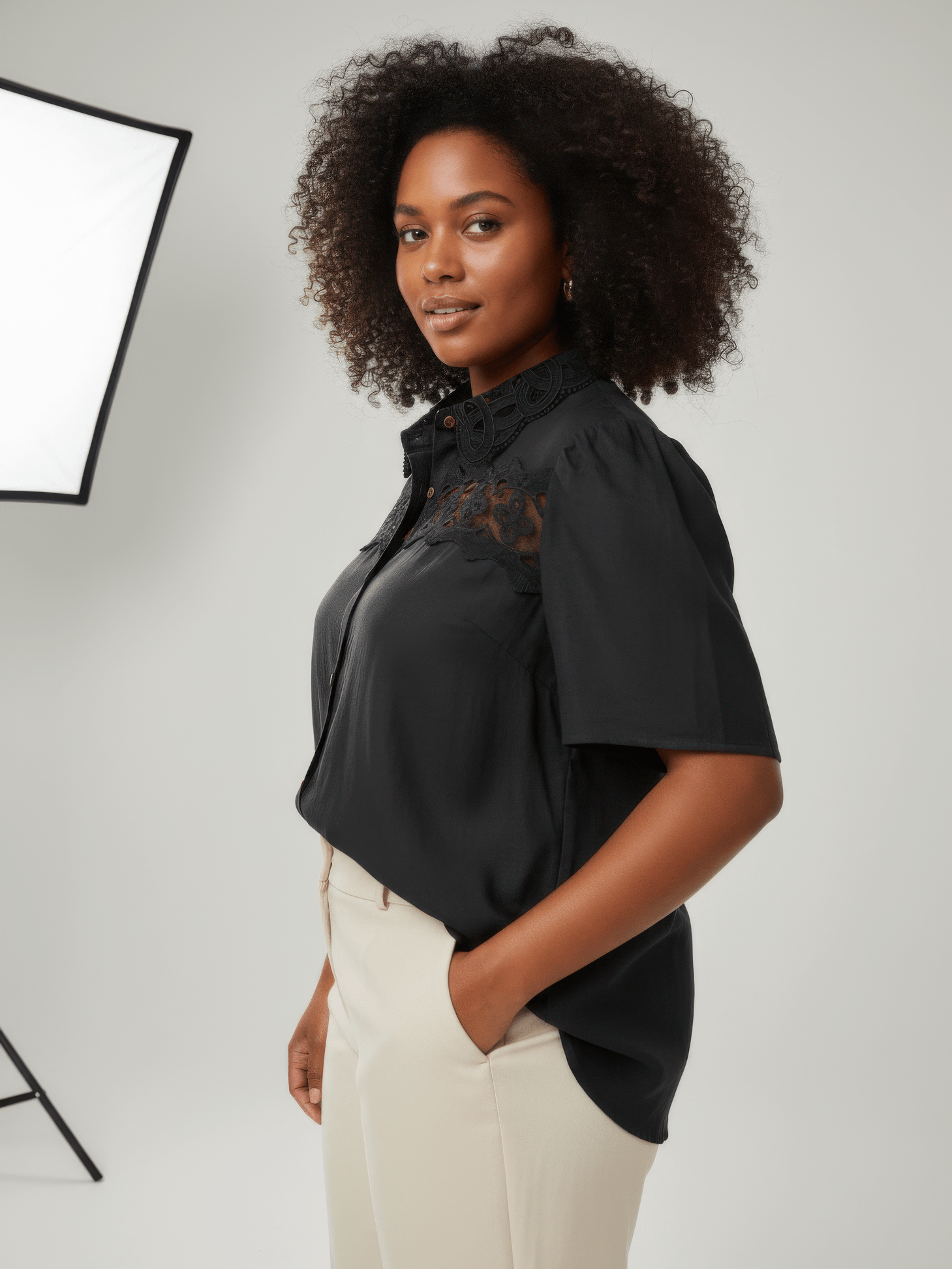 Model wearing The Inez Lace Panel Collared Blouse, a black button-front blouse with lace panel details.
