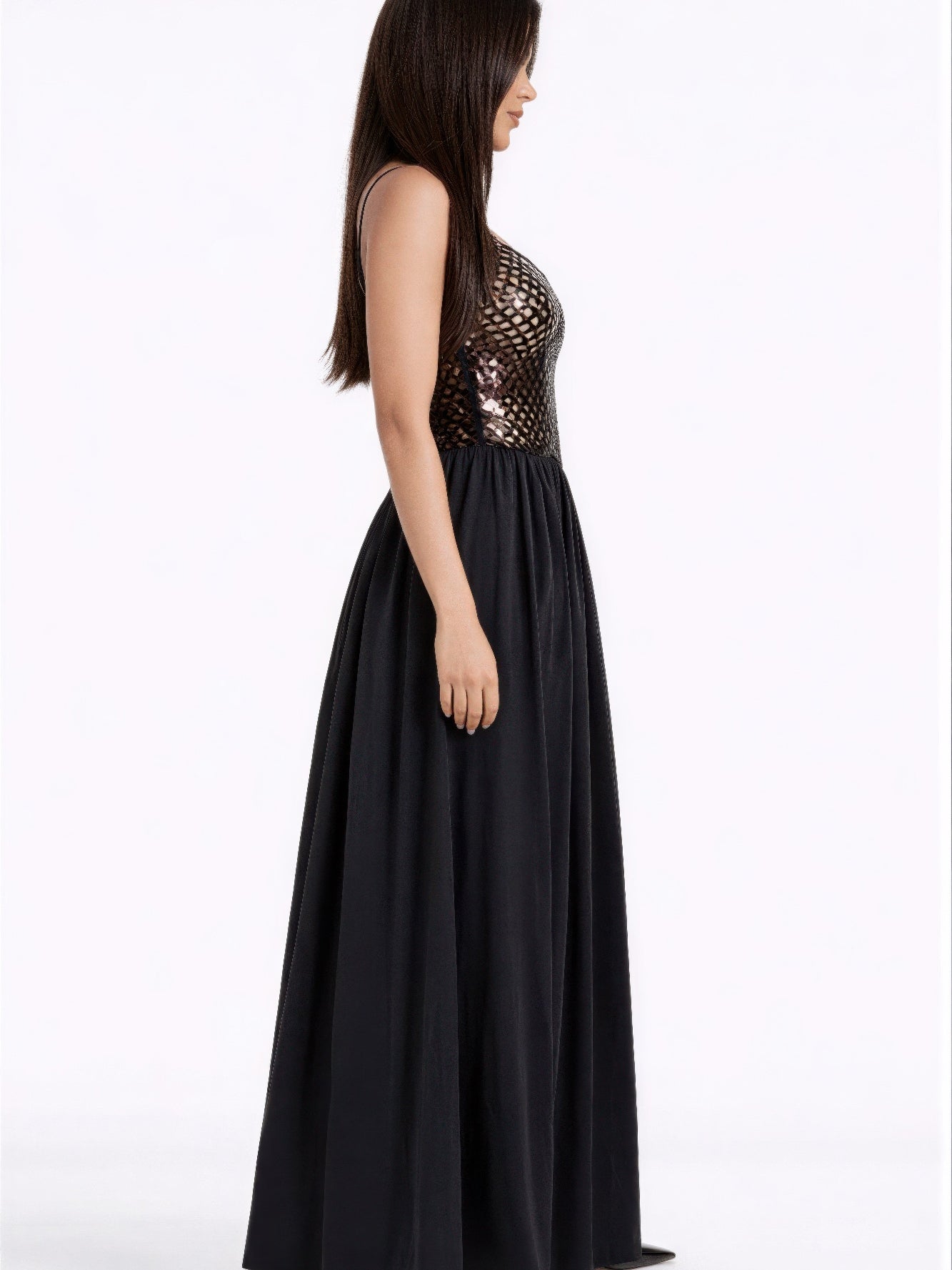 Woman in a Netted Sequin Maxi Dress showcasing elegant sequins and a flowing skirt from the side view.