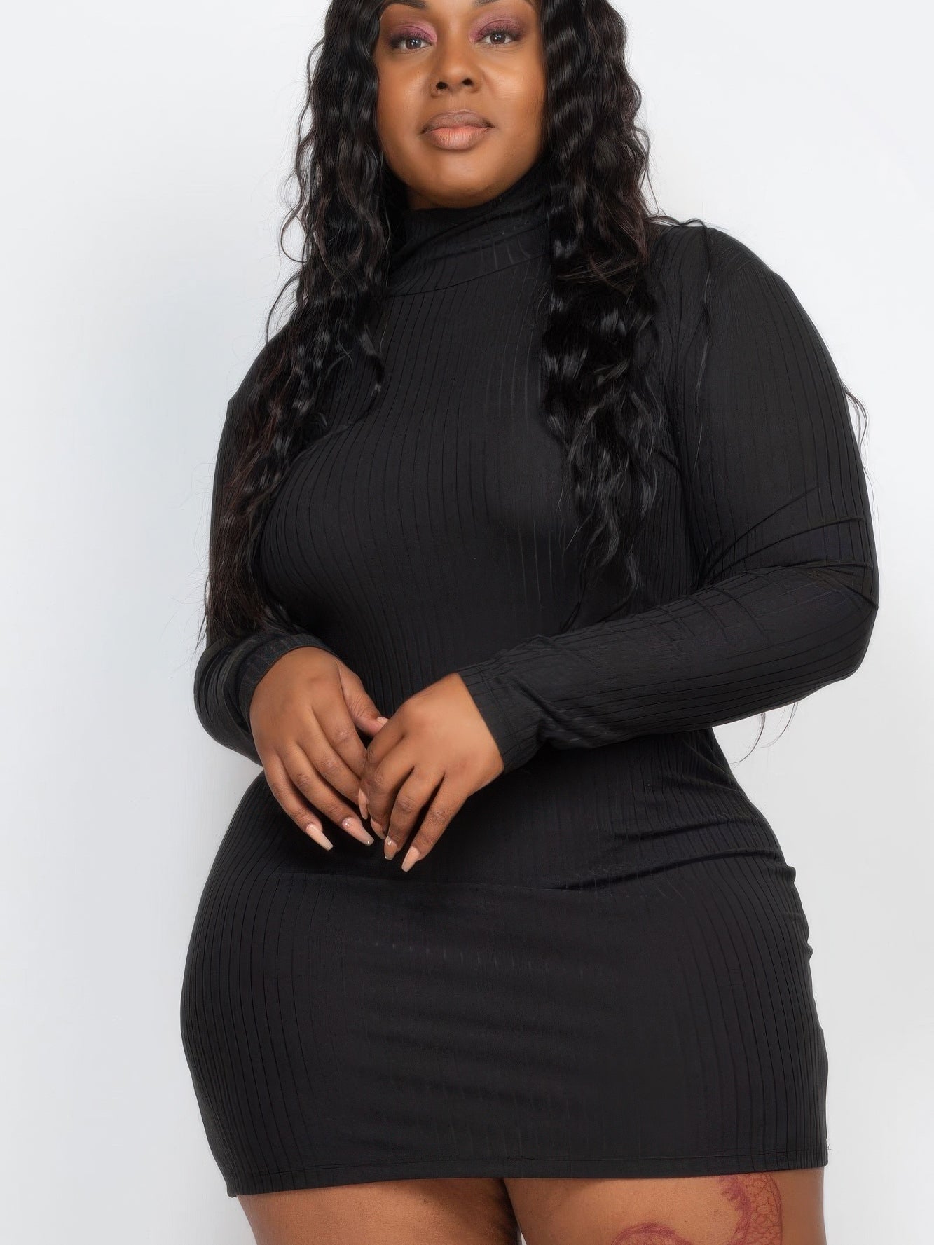 Plus size model wearing a black ribbed long sleeve mock neck mini bodycon dress, showcasing a flattering silhouette.