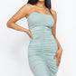 Woman in a 4-way ruched bodycon tube midi dress showcasing a sleek silhouette in a stylish mint green color.