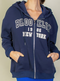 Graphic drop shoulder zip-up hoodie with "Brooklyn 1986 New York" logo, styled for a casual look and functional comfort.