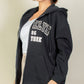 Model wearing a black Graphic Drop Shoulder Zipper Up Hoodie with Brooklyn logo, showcasing casual style and comfort.