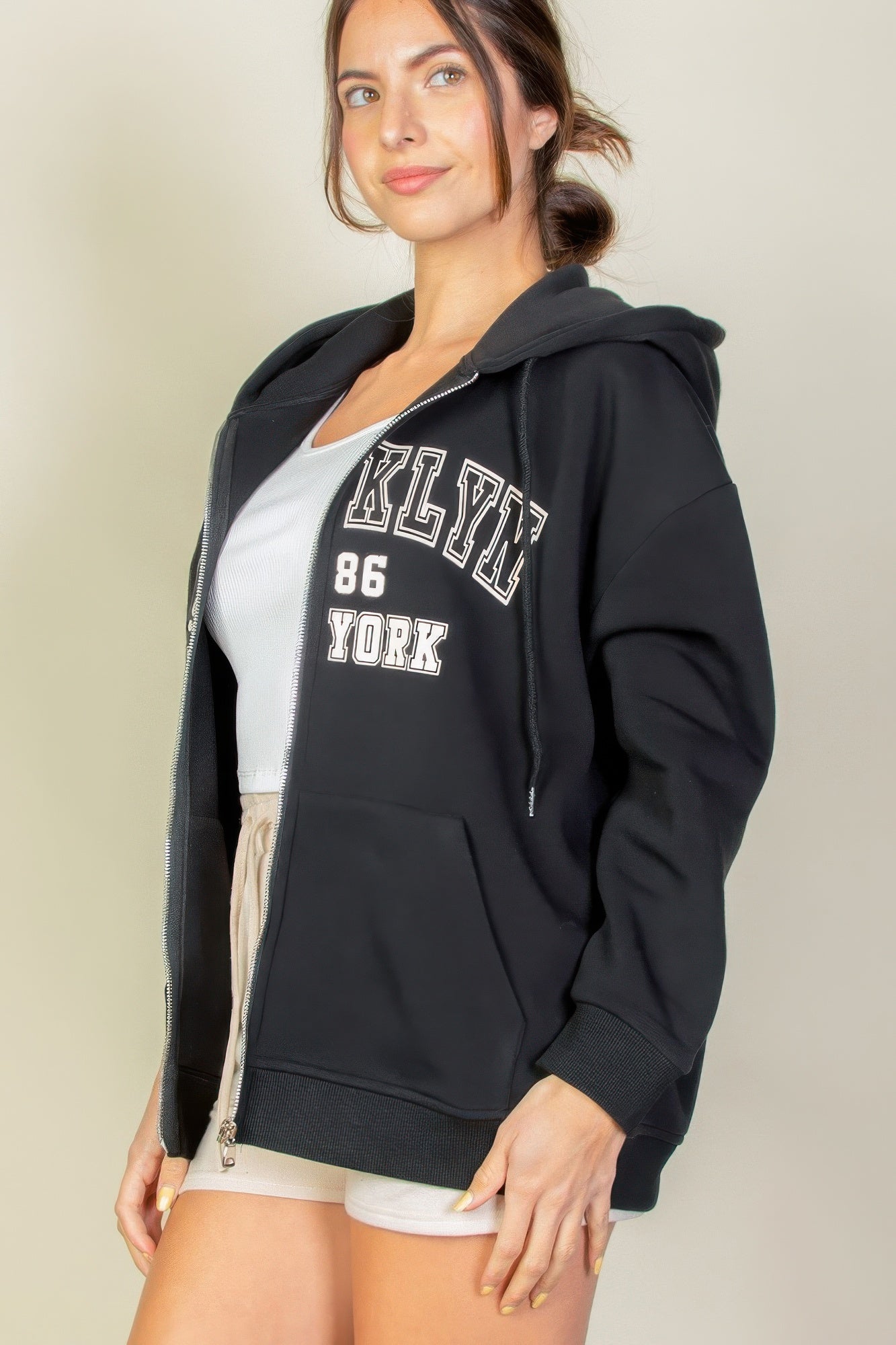 Model wearing a black Graphic Drop Shoulder Zipper Up Hoodie with Brooklyn logo, showcasing casual style and comfort.