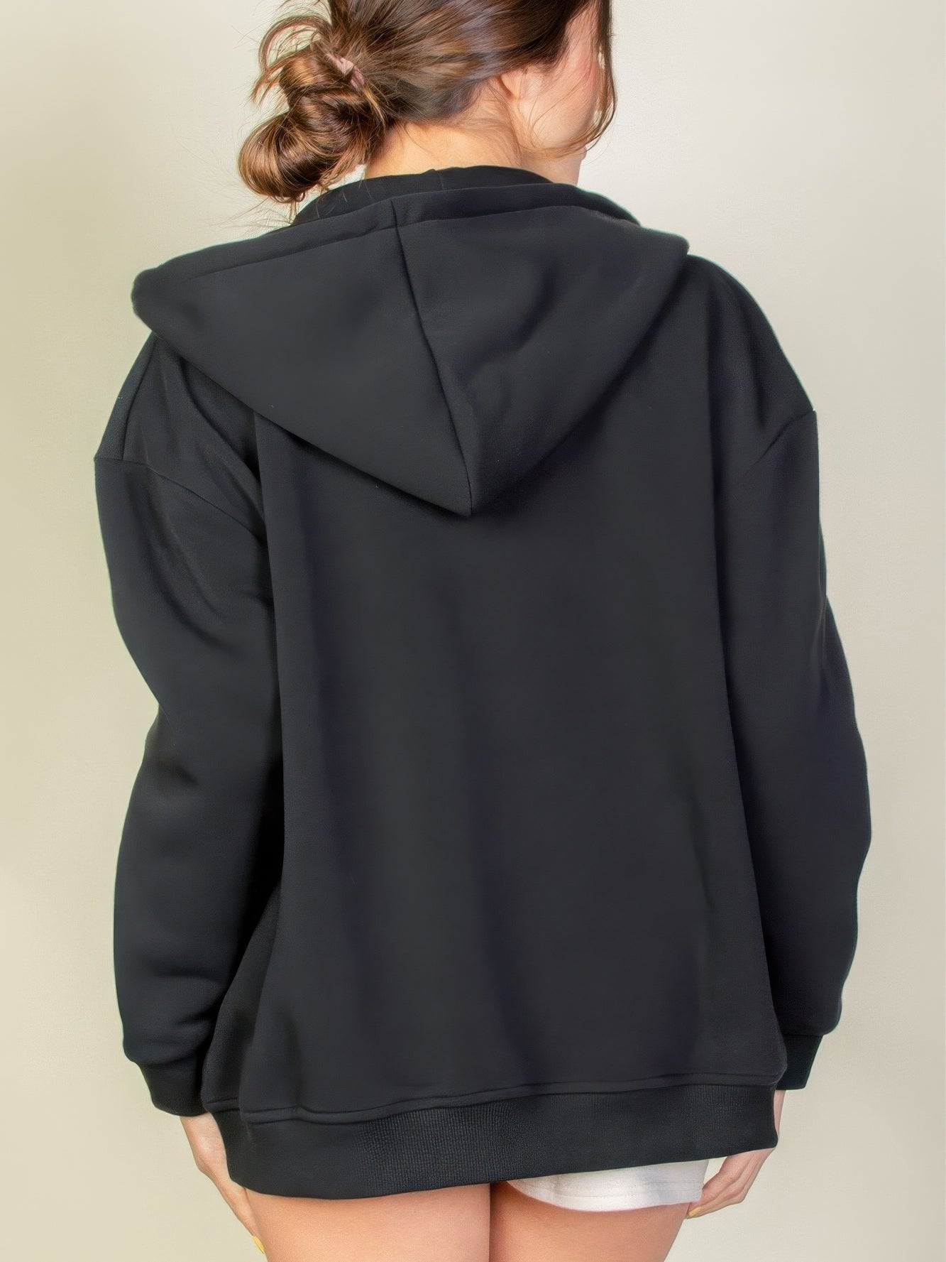 Back view of a woman wearing a black Graphic Drop Shoulder Zipper Up Hoodie, showcasing its casual style and comfort.