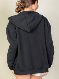 Back view of a woman wearing a black Graphic Drop Shoulder Zipper Up Hoodie, showcasing its casual style and comfort.