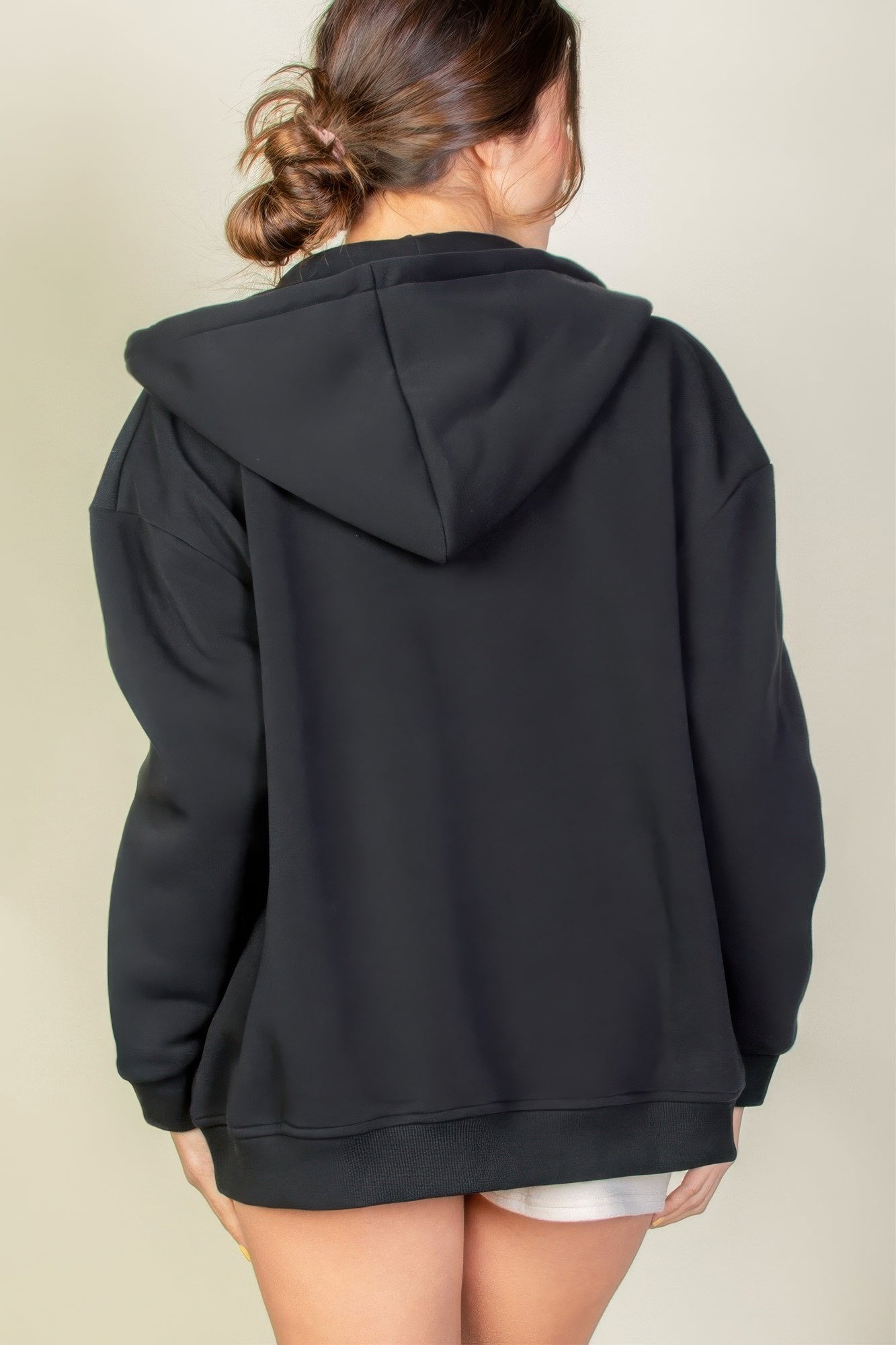 Back view of a woman wearing a black Graphic Drop Shoulder Zipper Up Hoodie, showcasing its casual style and comfort.