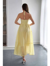 Solid Halter Muse Tiered Ruffle Long Dress in yellow with ruffled layers and halter neckline from the back.