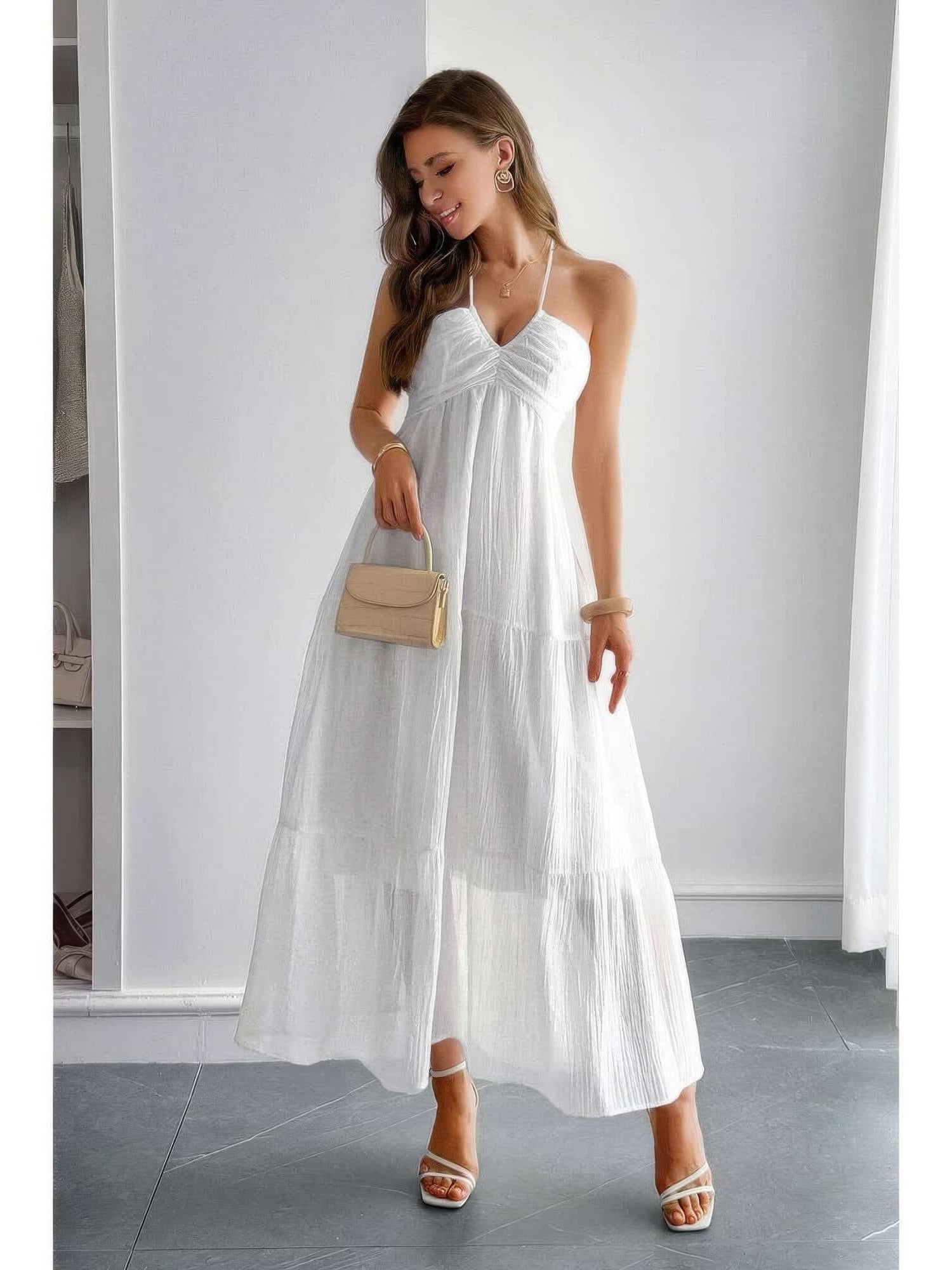 Model wearing a Solid Halter Muse Tiered Ruffle Long Dress in white, showcasing the flowy design and elegant ruffles.