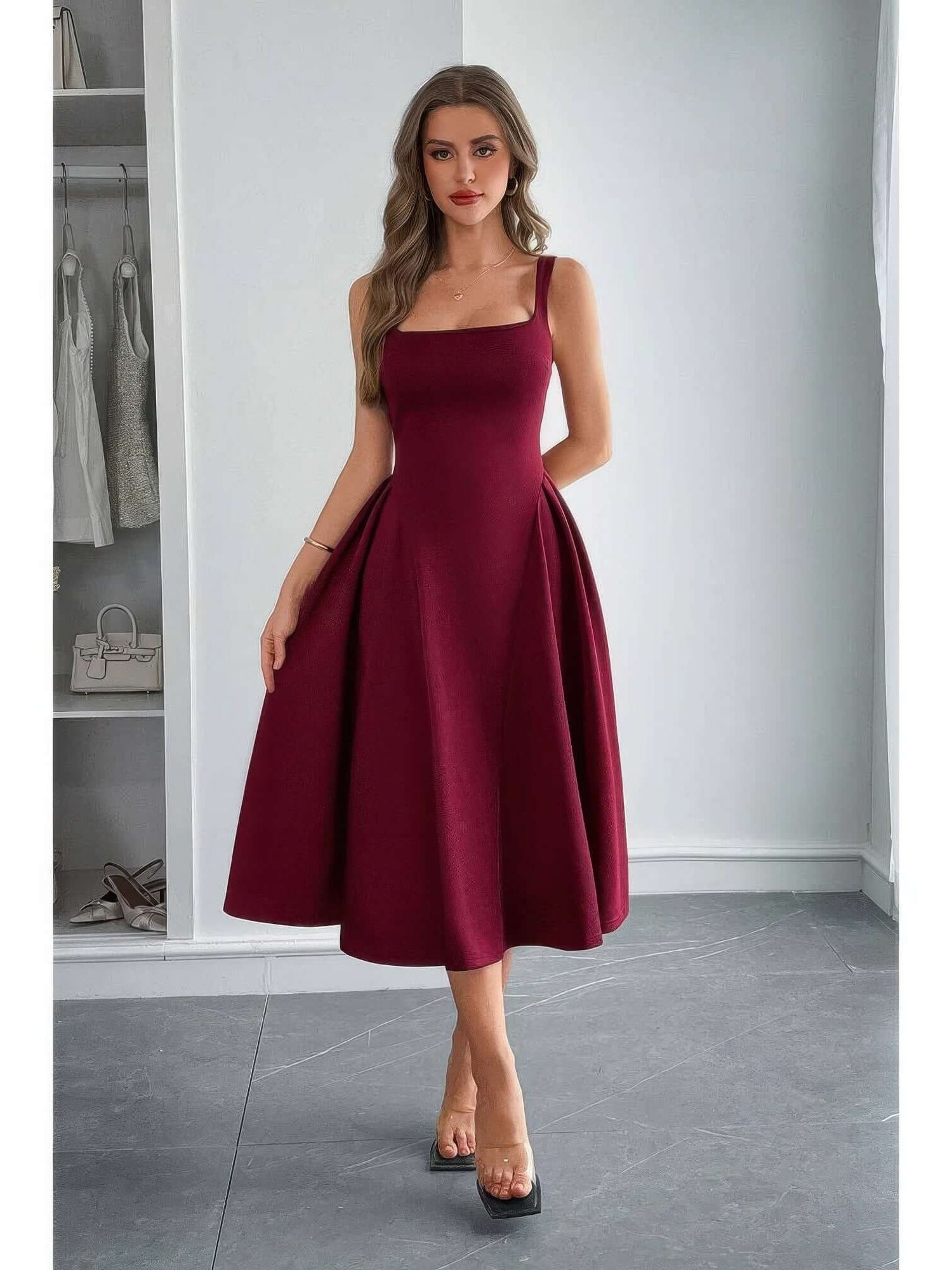 A woman wearing a Square Neck A Line Pleated Sleeveless Long Dress in burgundy, showcasing elegant design and flattering fit.