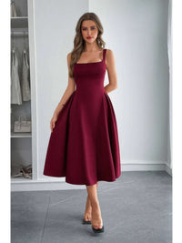 A woman wearing a Square Neck A Line Pleated Sleeveless Long Dress in burgundy, showcasing elegant design and flattering fit.