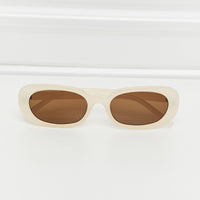 Oval Full Rim Sunglasses in cream with brown lenses, featuring a sleek polycarbonate design.