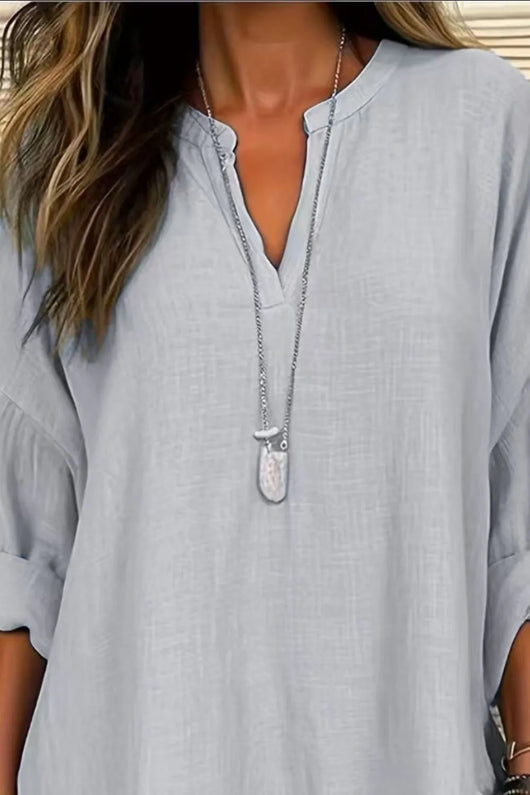Solid Color Notched Long Sleeve Blouse in light blue with a stylish notched neckline and a pendant necklace.