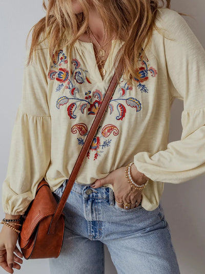 Embroidered Notched Balloon Sleeve Blouse featuring intricate embroidery, paired with denim and a stylish handbag.