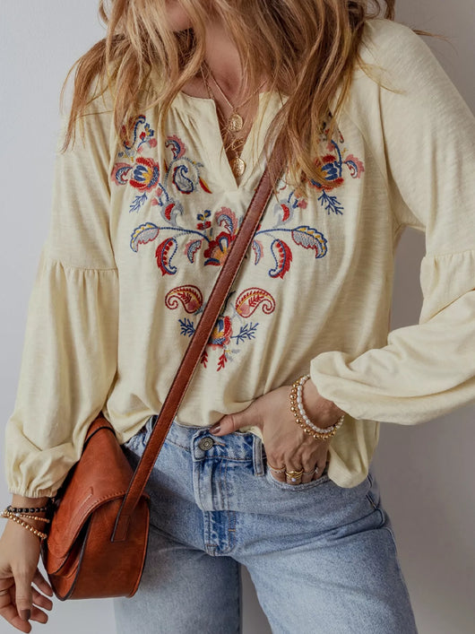 Embroidered Notched Balloon Sleeve Blouse featuring intricate embroidery, paired with denim and a stylish handbag.