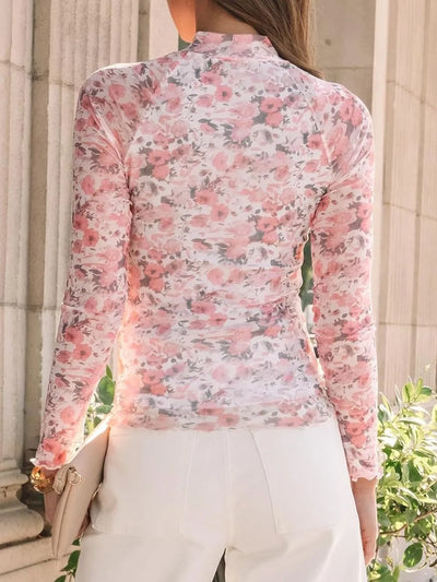 Back view of a model wearing a Lovelet Mock Neck Long Sleeve Top with a floral design.