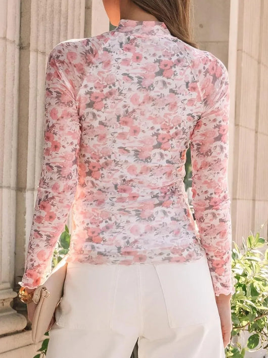 Back view of a model wearing a Lovelet Mock Neck Long Sleeve Top with a floral design.