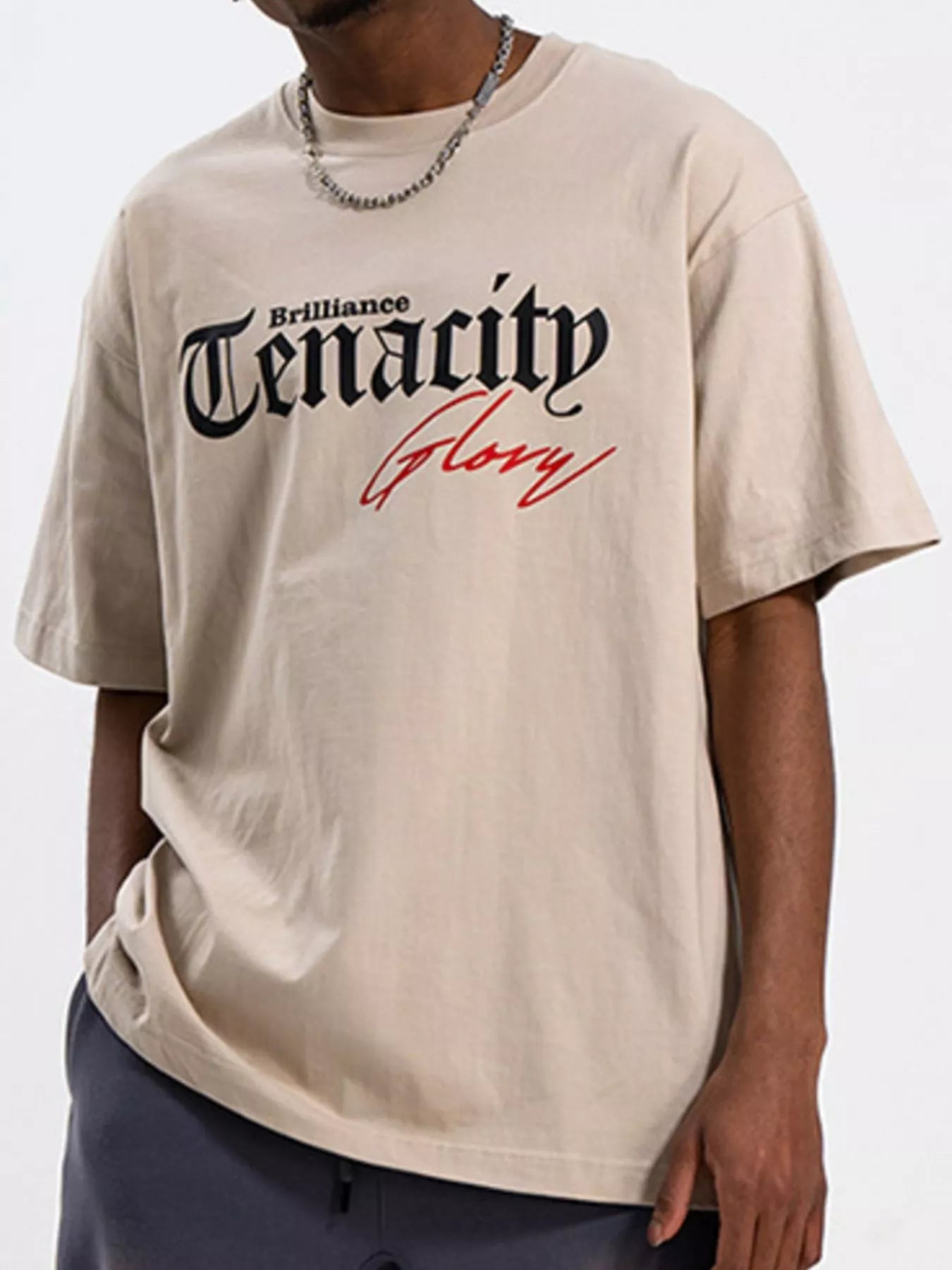 Men's TENACITY Round Neck Short Sleeve T-Shirt in beige with bold graphic print.