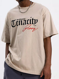Men's TENACITY Round Neck Short Sleeve T-Shirt in beige with bold graphic print.