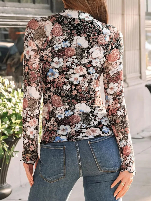 Back view of woman wearing Lovelet Mock Neck Long Sleeve Top with floral pattern and jeans.