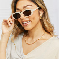 Oval Full Rim Sunglasses worn by a woman, featuring a stylish design and UV protection.