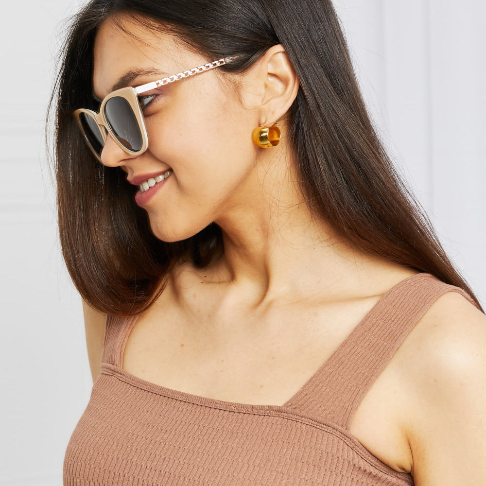 Model wearing Cat-Eye Acetate Frame Sunglasses with stylish earrings and a brown top.